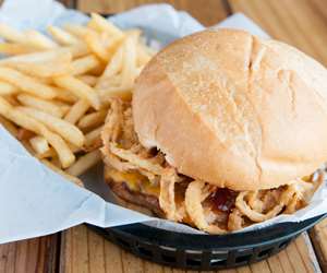 Sandwich in a basket with fries.